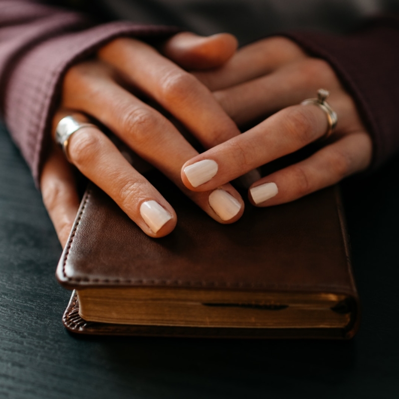 brown leather bifold wallet on gray textile